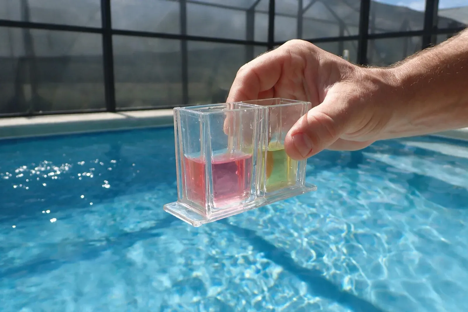 Test kit comparator held over a Naples pool edge