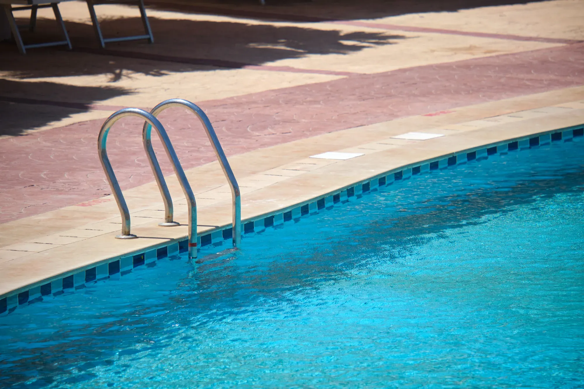 Stainless steel handrail at the edge of a pool